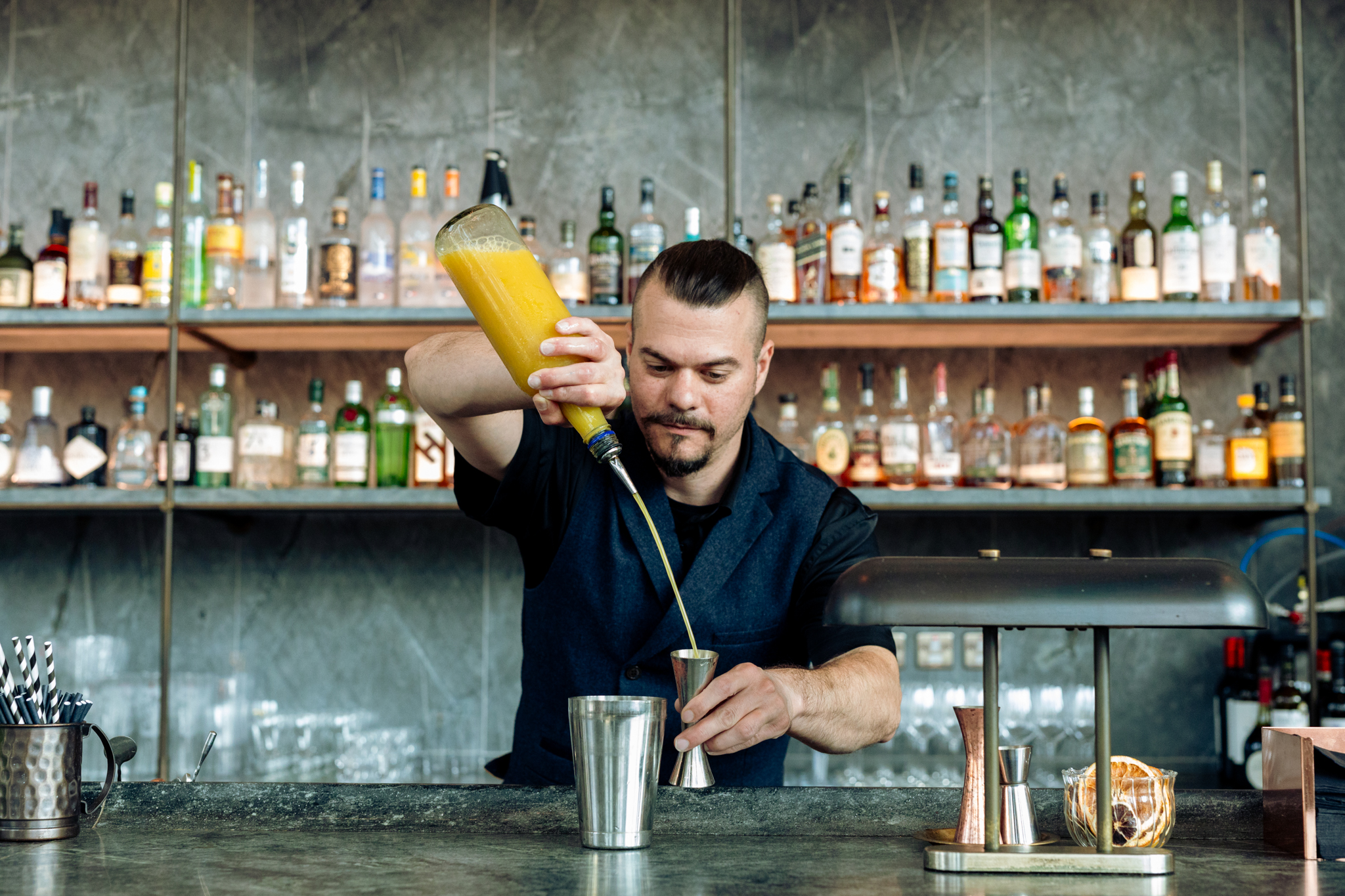 A bartender making a cocktail in a bar.